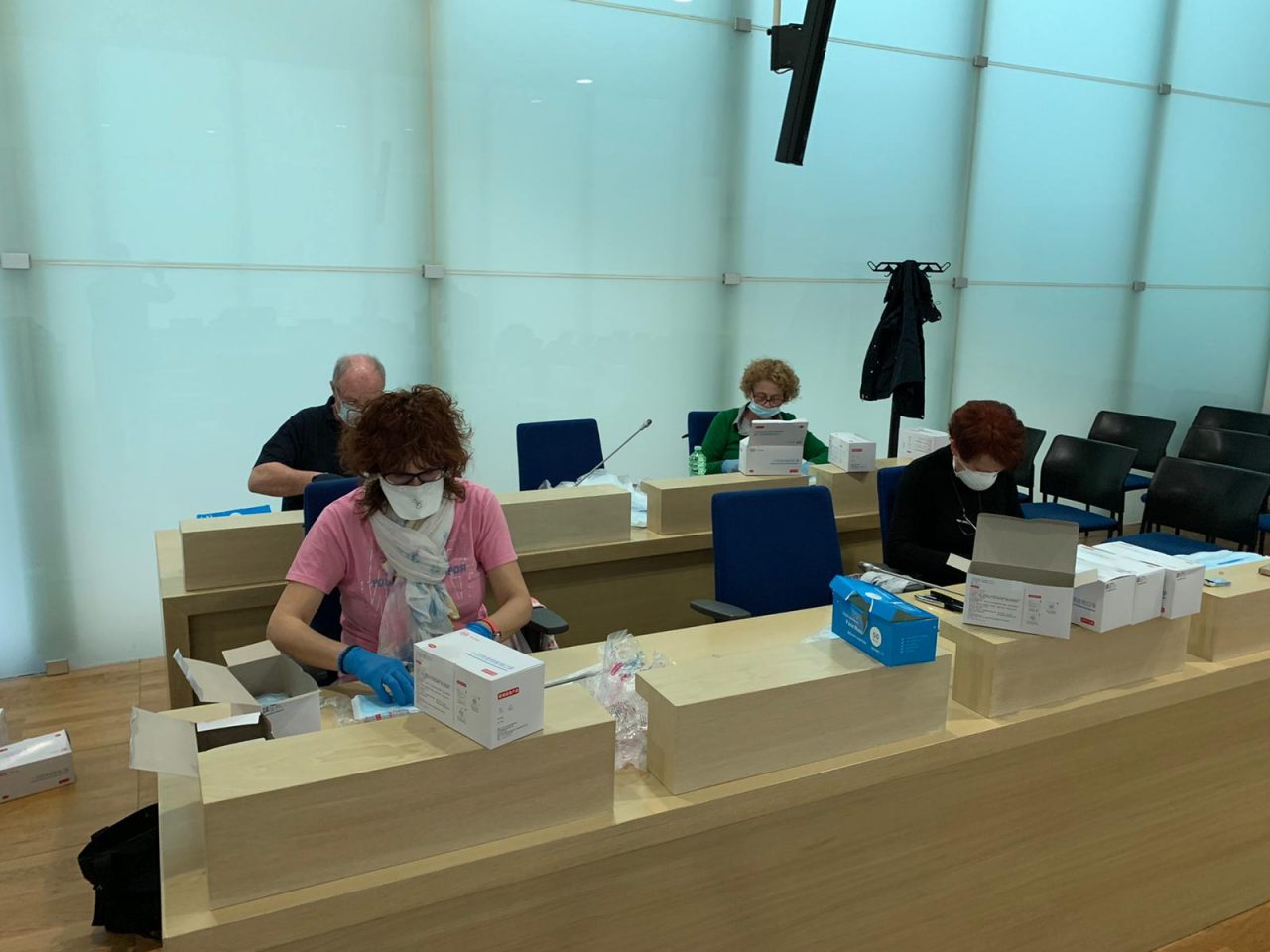 Volontari al lavoro per imbustare le mascherine LE FOTO