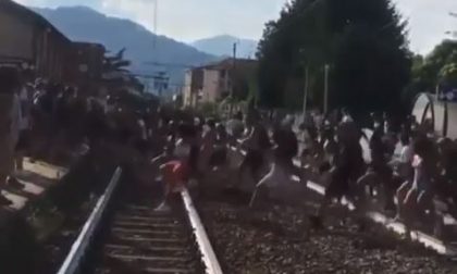 Scena assurda: decine di giovani “invadono” la ferrovia e attraversano i binari contemporaneamente VIDEO