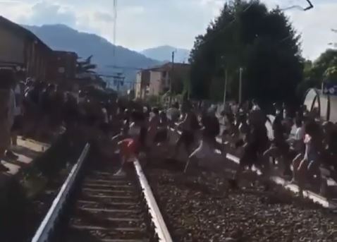 Scena assurda: decine di giovani “invadono” la ferrovia e attraversano i binari contemporaneamente VIDEO