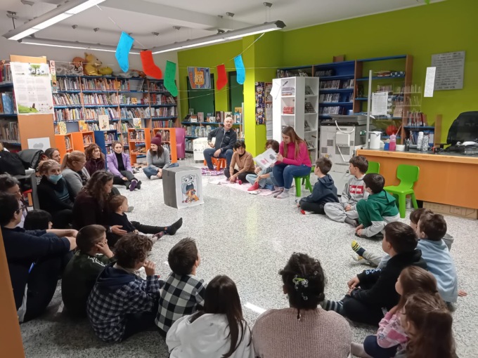 Bimbi e genitori in biblioteca con i calzini spaiati