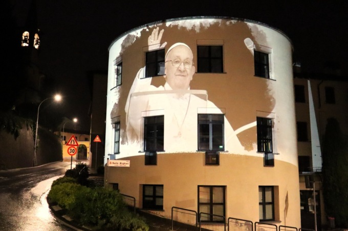 Il volto di Papa Francesco proiettato sul municipio