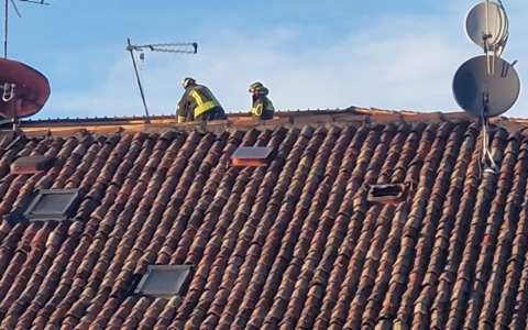 Per le raffiche di vento un tetto in fiamme, rami spezzati e lamiere pericolanti